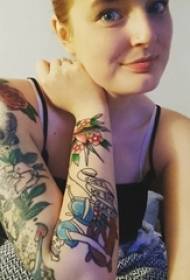 Il braccio della ragazza dipinge linee semplici con piccole immagini di tatuaggi di fiori freschi