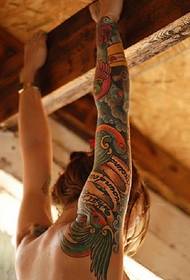 Il braccio del fiore della signora ha anche un modello di tatuaggio d'amore
