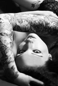 Braccio della ragazza sul nero grigio punto spina piccola pianta di vite fresca fiore braccio tatuaggio immagine