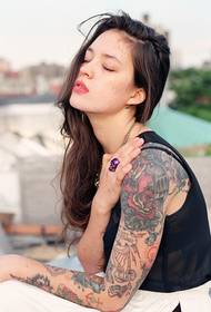 Bella ragazza con tatuaggio floreale braccio