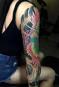 A bellezza di capelli longhi hà una stampa elegante di tatuatu di braccio fiore phoenix