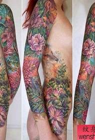 Immagine di uno spettacolo di tatuaggi consigliata Un modello di tatuaggio con braccio di fiori colorato donna