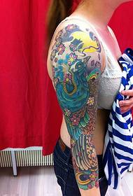 Female pretty flower arm peacock tattoo