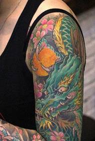 um padrão de tatuagem de dragão colorido cobrindo o braço da flor