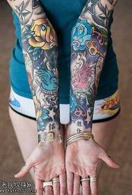 Ziedu roka, kas sniedzas, lai parādītu seksīgu tetovējuma modeli