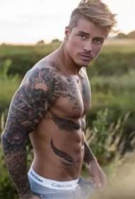 Tatu bello tippu - una foto di un uomo muscolare europeu è americanu tatuatu cù un bracciu fiore grande