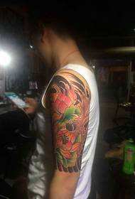 Immagini del tatuaggio del braccio del fiore che gli uomini possono anche tenere