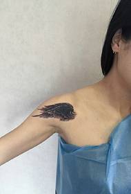 Ang hulagway sa tattoo sa feather sa usa ka batang babaye sa ilawom sa clavicle
