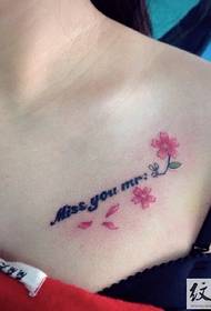 kis friss cseresznyevirág tetoválás a lány gallérján
