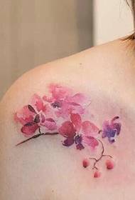 невелика татуювання вишневого цвіту збоку від жіночої ключиці