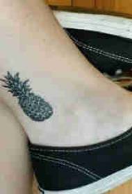 caviglia della ragazza del tatuaggio della pianta sull'immagine nera del tatuaggio dell'ananas