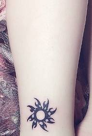 Alternatīvs maza saules tetovējuma raksts uz kailām kājām