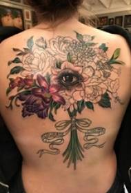 djevojke na leđima oslikane oslikane gradijentom jednostavnog buketa biljaka i slike tetovaže očiju