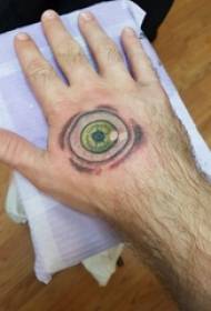 ручно тетовирана мушка рука на полеђини обојене слике тетоважа за очи