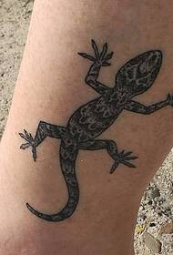unha tatuaxe de gecko negro no nocello do becerro