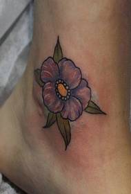 Besonders schön ist ein kleines frisches lila Blütentattoo auf den nackten Füßen