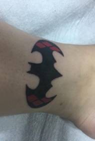 Ant kulkšnies kaulų padaryta tatuiruotės vyro sportininko kulkšnis ant spalvoto Batmano logotipo tatuiruotės paveikslo