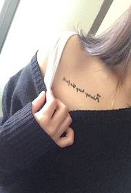 ragazza sexy con un semplice tatuaggio inglese sulla clavicola