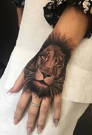 Imagens de tatuagem de leão de estilo realista nas costas de uma mão feminina