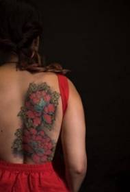 Ragazza tatuata sul retro di una foto di un tatuaggio floreale colorato