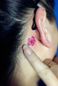 um pequeno padrão de tatuagem de flores na parte de trás da orelha é muito natural