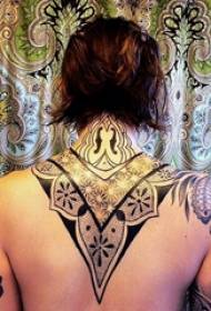na het tatoeëren Terug vrouwelijk meisje op de achterkant van een zwarte tribal tattoo-foto