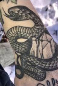 Tattoo snake pattern on the back of a male hand with a black tattoo snake pattern