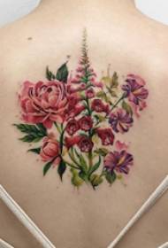 Tatuita malantaŭa junulino ĉe la dorso de la delikata floro de tatuaje