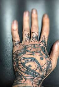 La tatuaje de nigra griza inko sur la dorso de la mano estas bela
