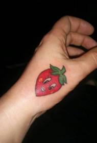 食物紋身女孩的手在彩色草莓紋身圖片的背面