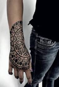 9 mustaa pistettä tatuointikuviota käden takana käsivarteen