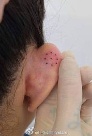 Pikčast vzorec tetovaže na ušesu