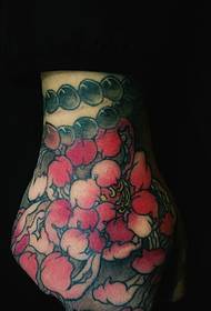 hand- mbrapa e mbuluar me tatuazh të bukur të vogël me petale