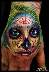 un tatuaj colorat de fată moarte pe spatele mâinii