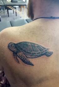 Ragazzo maschio tatuato sul retro di una foto di un tatuaggio di tartaruga nera