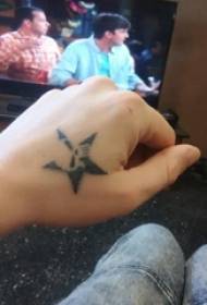 la mà del noi del tatuatge d'estrelles de cinc puntes a la imatge negra del tatuatge de cinc puntes