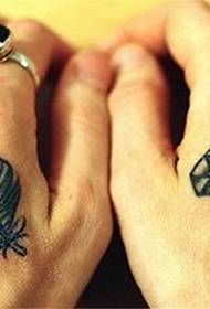 tatuaż z diamentem i piórem z tyłu dłoni