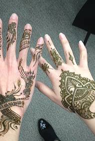 Tangan tangan langsing kanthi gambar tato Henna sing ayu