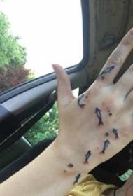 mà del tatuatge de la mà del nen a la imatge de tatuatge de peix petit