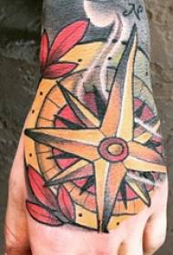 hand-terug getatoeëerde mannenhand op de achterkant van een gekleurde kompas tattoo-afbeelding