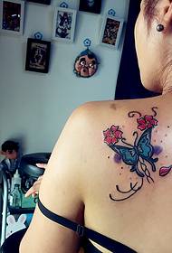 彩色的蝴蝶紋身圖案在女孩的背上