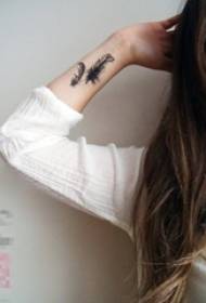 sort på håndleddet på pigens håndled let fjer tatoveringsbillede