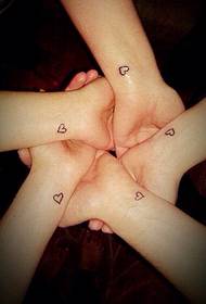 majhna tetovaža v obliki srca na zapestju med puncami