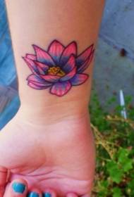 farget lotus tatoveringsmønster på det kvinnelige håndleddet