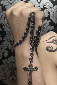 riešas ant karoliukų grandinėlės kryžiaus tatuiruotės