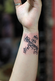six-character mantra tattoo on the wrist