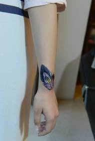 mergaitės riešas, pilnas spalvingo plunksnos tatuiruotės modelio