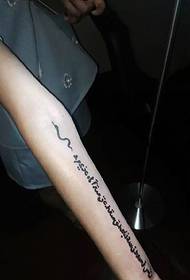 Ingliskeelne sõna tattoo tattoo tüdruku randmel