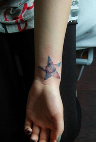 다섯개 별과 별이 빛나는 문신 패턴을 가진 소녀의 손목
