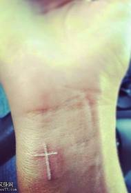 nadgarstek biały niewidoczny wzór tatuażu krzyżowego